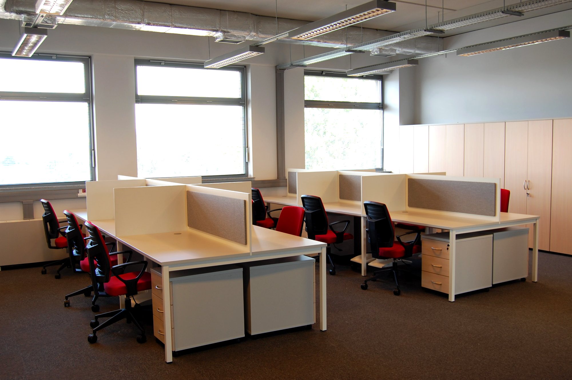 Biuro open space — stanowiska pracy z przegrodami i zabudową szafową